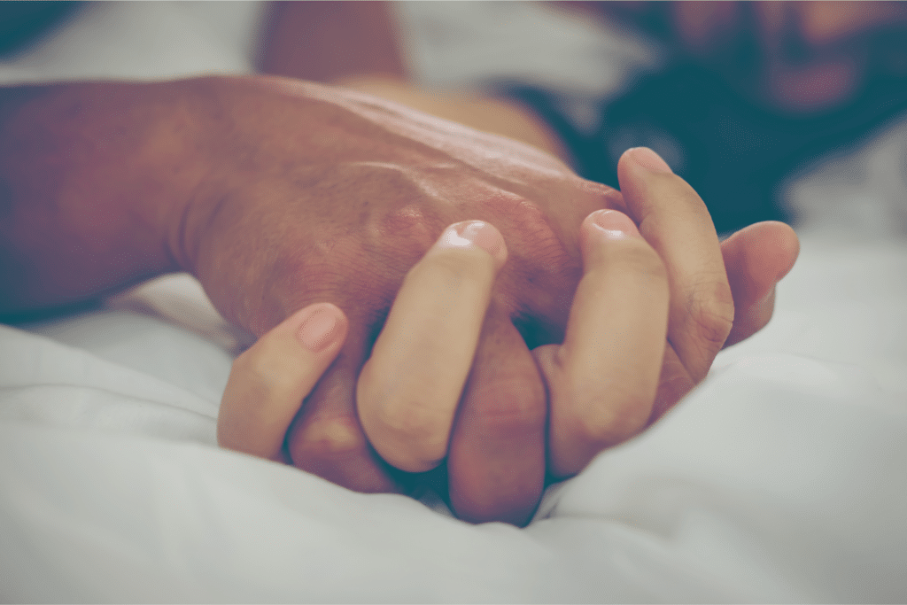 Férfi és nő keze összefonódik egy bizonyos szexpóz közben
